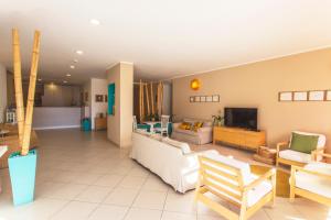 a living room with a couch and a tv at Hotel Baia Del Sole in Marina di Ragusa