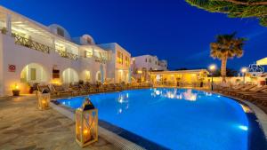 a swimming pool in front of a hotel at night at Hotel Mathios in Akrotiri
