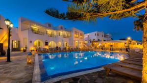 a pool in front of a hotel at night at Hotel Mathios in Akrotiri