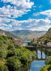 a river in a town with a bridge at Dois Lagares House in Pinhão