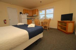 Sea Gull في باكستون: غرفة نوم بسرير ومطبخ مع طاولة