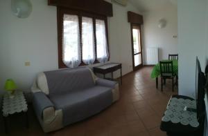 a living room with a couch and some windows at B&B Traghetto in Porto Garibaldi