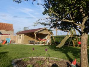 un patio con un tobogán y un parque infantil en Holiday Home Cuylehoeve, en Leffinge