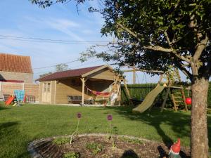 a yard with a slide and a playground at Holiday Home Cuylehoeve in Leffinge