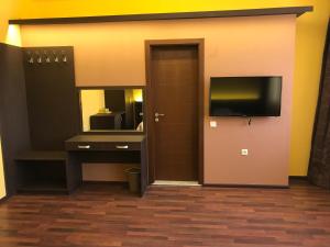 ein Zimmer mit Badezimmer mit Waschbecken und Fernseher in der Unterkunft Център in Plewen