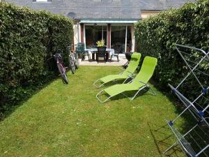 deux chaises vertes posées dans l'herbe dans une cour dans l'établissement Marina Apartment, à La Forêt-Fouesnant 11 autres photos