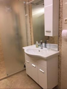 een badkamer met een witte wastafel en een spiegel bij Център in Pleven