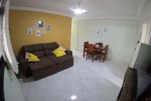 a living room with a couch and a table at Apartamento Residencial Angélica em Guarapari a 150m do mar in Guarapari