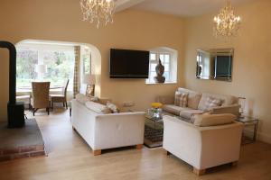 a living room with two white couches and a tv at Dean End Apartment 2 in Ross on Wye