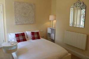 a bedroom with a white bed and a mirror at Dean End Apartment 2 in Ross on Wye