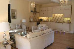 a living room with a couch and chairs and a kitchen at Dean End Apartment 2 in Ross on Wye