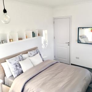 - une chambre blanche avec un lit et des oreillers dans l'établissement Deluxe Penthouse Charming Location Rooftop Views, à Marsaxlokk