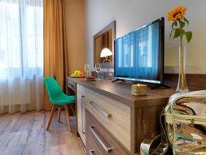 a desk with a television and a chair in it at Hotel Viktor in Bratislava
