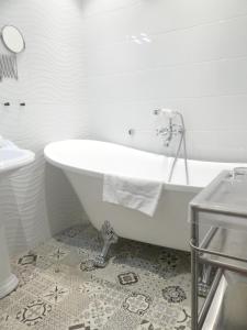 y baño con bañera blanca y lavamanos. en Hôtel de la Plage, en Dieppe