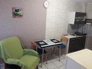 a small kitchen with a table and chairs and a stove at Meublés B-D in Bains-les-Bains