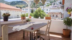 una mesa y sillas en un balcón con vistas en Douskos Guesthouse en Hydra