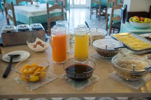 a table topped with glasses of orange juice and fruit at Hotel Acquamarina in Portoferraio