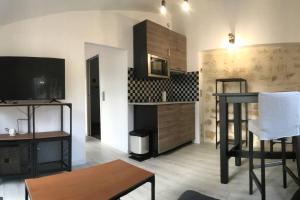 a living room with a table and a kitchen at Dépendance cosy dans le Vexin, terrasse et jardin in Us