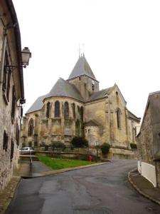 een oude stenen kerk met een straat ervoor bij Dépendance cosy dans le Vexin, terrasse et jardin in Us
