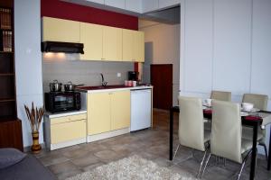 a kitchen with yellow cabinets and a table with chairs at Cozy apartments in Komotini