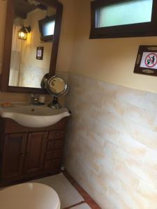 La salle de bains est pourvue d'un lavabo, d'un miroir et de toilettes. dans l'établissement Casa Gle, à SantʼAndrea