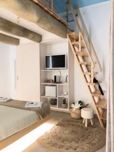 a bedroom with a bed and a staircase with a tv at b&b le onde praiola in Terrasini