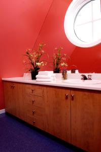 a bathroom with a sink and a red wall at Chalets Multivoile 4 Saisons in Trois-Rivières