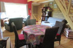 salon ze stołem i krzesłami w obiekcie Le Seringat w mieście Saint-Léonard