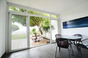 Pokój ze stołem i krzesłami oraz przesuwnymi szklanymi drzwiami w obiekcie AguaMarina w mieście Benajarafe