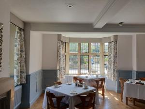 uma sala de jantar com duas mesas e uma janela em The Old New Inn em Bourton on the Water