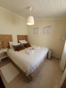 a bedroom with a large bed with towels on it at Páteo Badajoz in Sintra