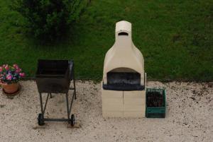 a large milk bottle with a grill and flowers at Agriturismo"Il Sagrato di Assisi" appartamenti,camere in Assisi