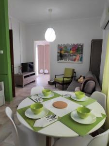 una mesa de comedor con platos y tazones verdes en Cozy apartments, en Komotiní