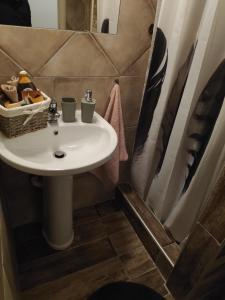 y baño con lavabo blanco y espejo. en Cozy apartments, en Komotiní