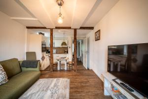 ein Wohnzimmer mit einem Sofa und einem TV in der Unterkunft Ferienwohnungen Finkenherd 5 in Quedlinburg