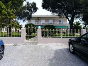 a fence in front of a house with a car at Cozy apartments in Komotini