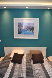 - une chambre dotée d'un lit avec un mur bleu dans l'établissement Lux apartman Čačak, à Čačak