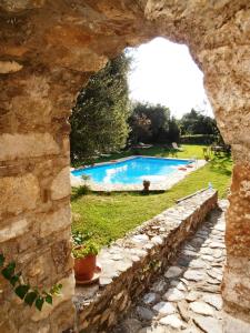 a stone wall with a view of a swimming pool at Byzantion Hotel in Mystras