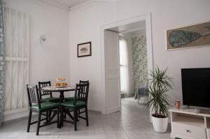 comedor con mesa, sillas y TV en Ai Mori en Palermo