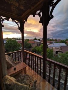 a gazebo with a bench on a balcony with a sunset at Guest House Top Floor in Tʼelavi