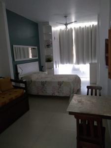 1 dormitorio con 2 camas, sofá y ventana en Apartamento Copacabana, en Río de Janeiro