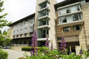 a building with purple flowers in front of it at Carey Centre on UBC campus in Vancouver