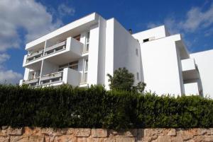 un edificio blanco en la parte superior de una pared de piedra en Apartamentos Martha's, en Palmanova