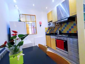 a small kitchen with a refrigerator and a table at Flat 1 at 6 Taunton Mews in London