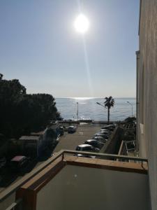 a balcony with a view of a parking lot and the ocean at La Finestra sul Mare in Letojanni