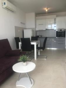 a living room with a couch and a table and a kitchen at Apartman Apollo 2 Makarska in Makarska