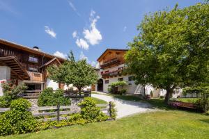 an estate in the mountains with a fence and trees at Strasserhof tenuta-Weingut in Varna
