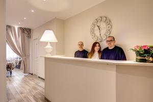 a group of three people standing behind a counter at Casa Tua Vaticano Guest House in Rome