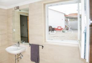 a bathroom with a sink and a window at Casa das Pipas Palmela #1 in Pinhal Novo