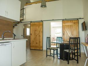 a kitchen with wooden doors and a table with chairs at Casa das Pipas Palmela #1 in Pinhal Novo
